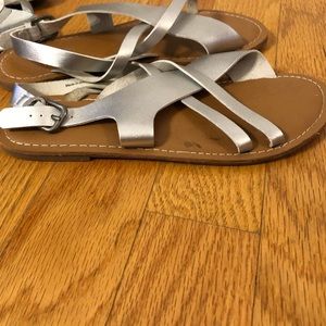 Silver flat sandals.